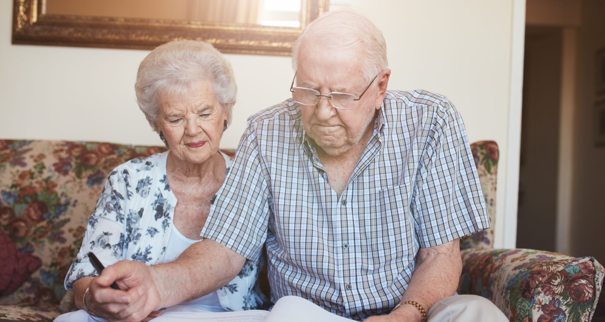 Elderly man and woman looking over revocable living trust document