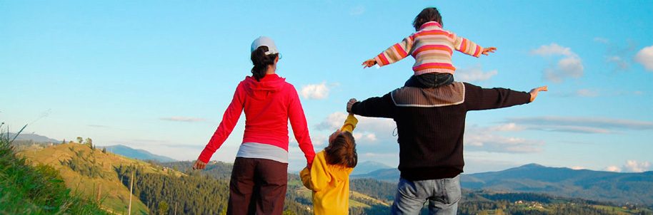 Family Going For a Hike with One Child Holding Mother's Hand and One on Father's Shoulders