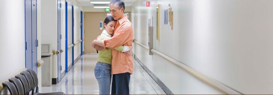 Man Woman Embracing in Hospital Waiting Area
