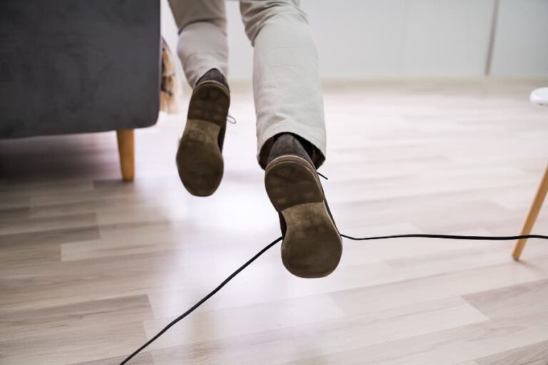 Close up of a man’s legs tripping over an electrical cords