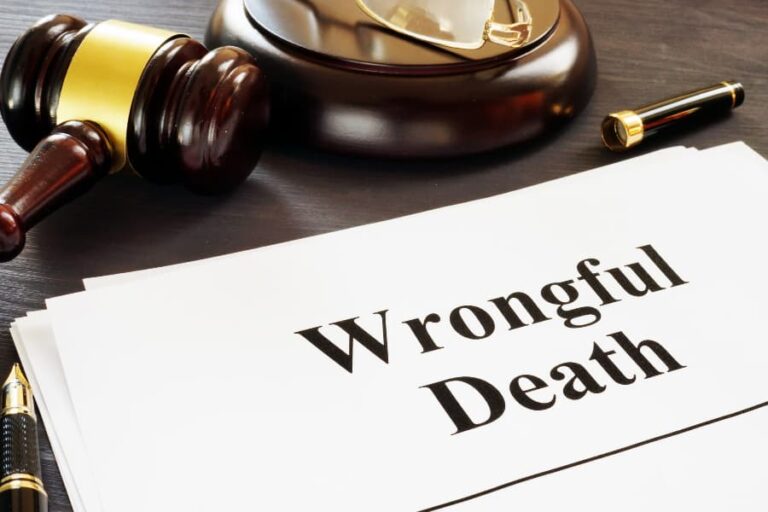 Wrongful death document sitting on a desk with a gavel, pen, and eyeglasses