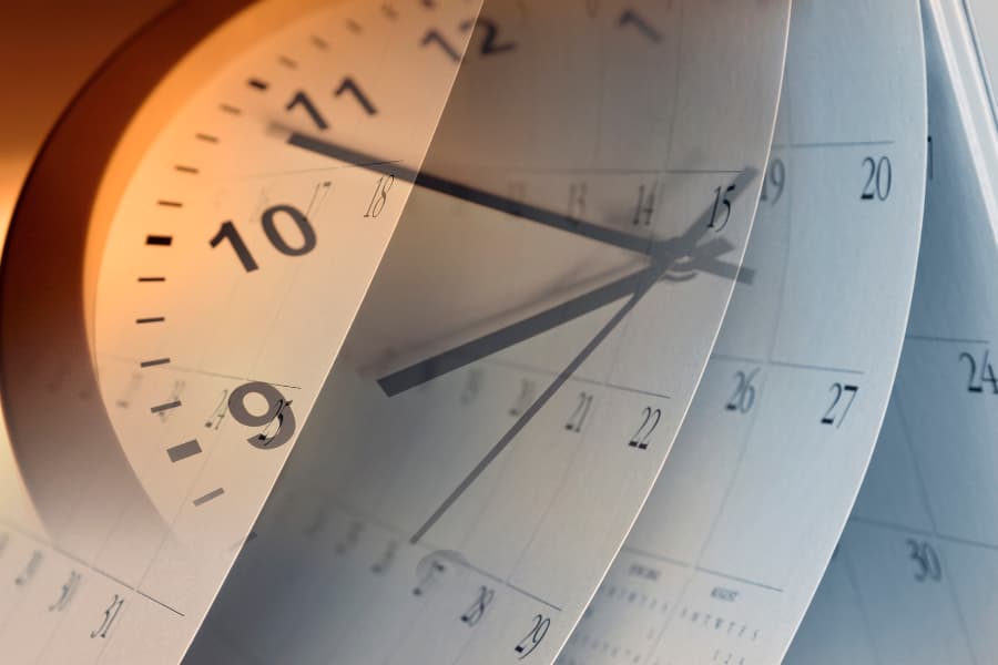 Close-up of a clock and calendar with pages flipping